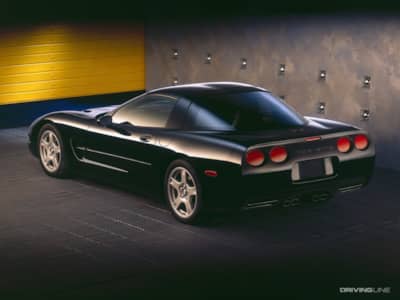 Black Chevrolet Corvette C5 in front of a steel wall
