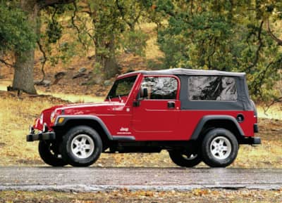 Jeep Unlimited LJ in the woods in red
